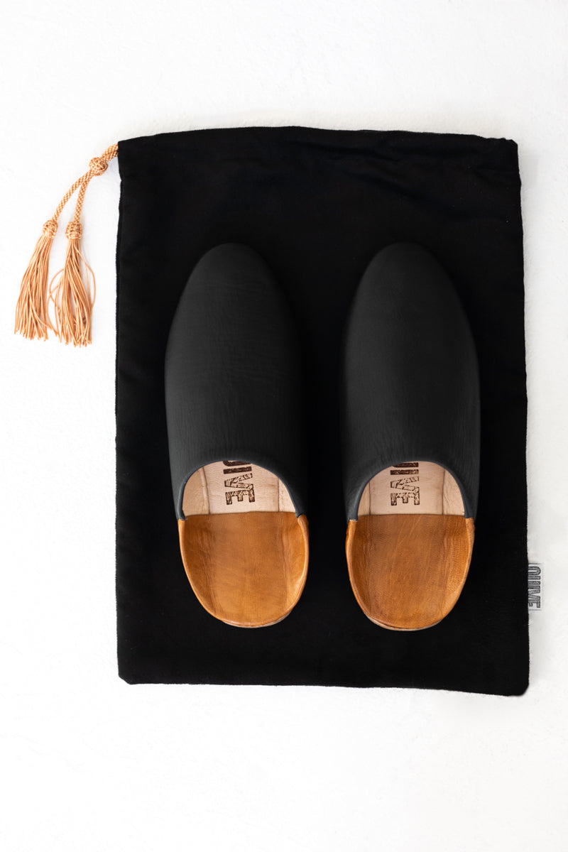 above shot of Ouive black leather house shoe with black travel drawstring dust bag
