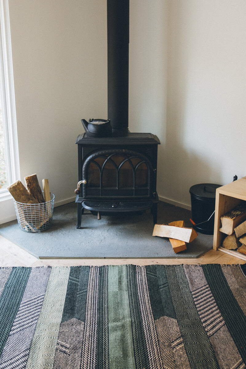 Striped Chadoui Zanafi - Forrest - Flatweave Moroccan Rug with black potbelly stove