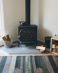 Striped Chadoui Zanafi - Forrest - Flatweave Moroccan Rug with black potbelly stove