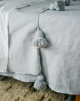 Close up of Gray Pom Pom Tassels on Moroccan Blanket