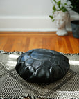 Black small leather cushion for sitting on the floor