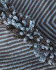 Close up of side fringe of Light Blue + Charcoal Made-to-order Zanafi Moroccan Wool Rug