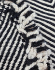 Close up of side fringe of Black + White Made-to-order Zanafi Moroccan Wool Rug