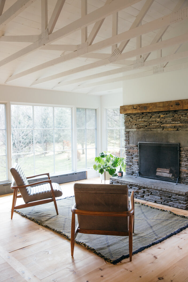 Living room with fireplace and flatweave black and olive green Moroccan wool rug