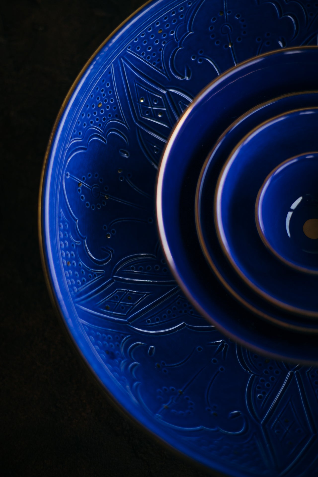 Blue ceramic plates with intricate designs on a dark background