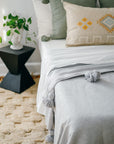 Grey Moroccan Pom Pom Blanket Styled on Bed