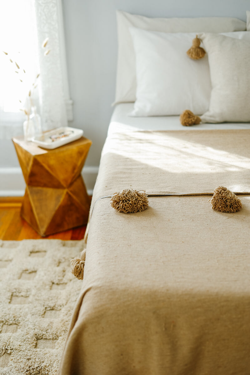 Moroccan Pom Pom Blanket on Bed - Beige