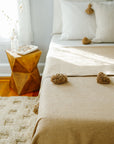 Moroccan Pom Pom Blanket on Bed - Beige
