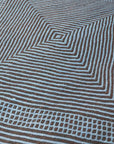 Close up at angle of Light Blue + Charcoal Made-to-order Zanafi Moroccan Wool Rug